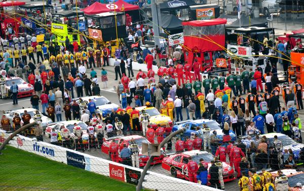 Drivers and crews pause before the race to say the Pledge of Allegiance.