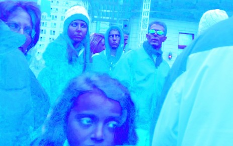 People on urban sidewalk, with blue tint.