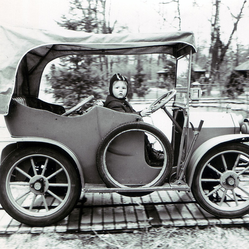 Kid in old car.