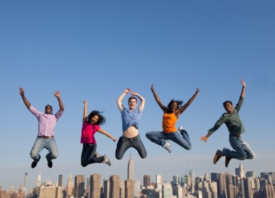 people jumping in front of city skyline