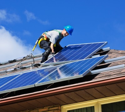 man on roof installing solar panels