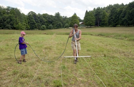 Board member Konrad Scheltema, with help from his son Oliver, uses a wand applicator to apply a 50/50 mix of sanitized urine and water to a test plot.