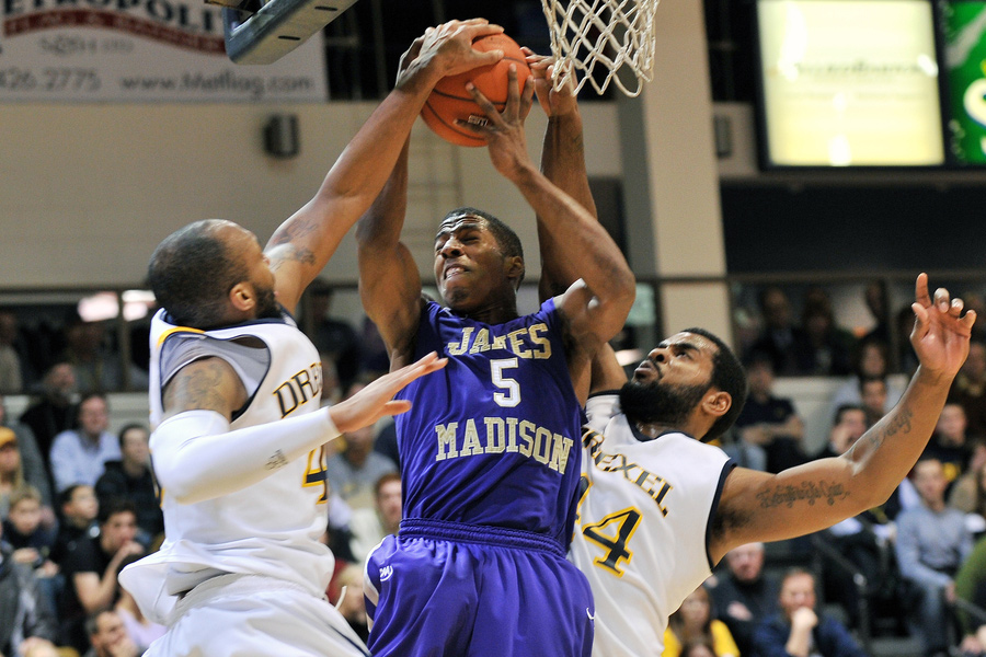 James Madison guard Alioune Diouf (5) battles for a rebound with two Drexel players during the NCAA basketball game between Drexel and JMU February 22, 2012 in Philadelphia