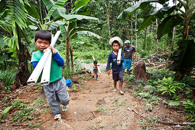 Waorani children haul components for clean-water systems to the village of Yawepare. Some of their homes are inside an oil block run by Andespetro, pollution from which flows into the Río Tiputini.