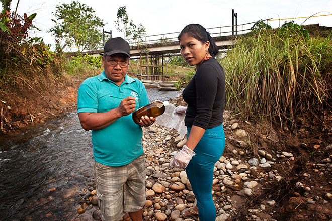 Emergildo Criollo and Nemonte Nenquimo take water samples downstream from a recent Petroamazonas oil spill that occurred just outside the town of Lago Agrio, in a tributary of the Río Aguarico.