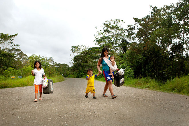 A family sets out along the Via Maxus, which cuts through Yasuní National Park, to collect water from a station operated by the Spanish company Repsol.