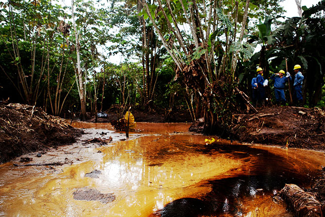 Petroamazonas workers observe a recent oil spill upriver from Emergildo Criollo’s community, Cofán Dureno.