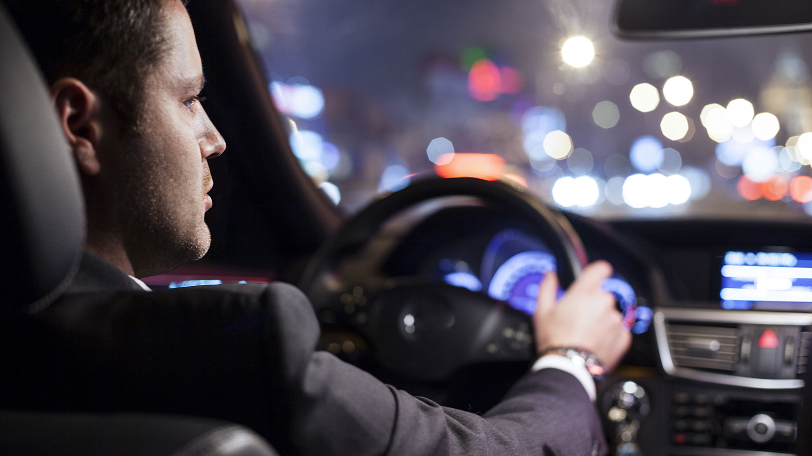 Businessman driving car at night