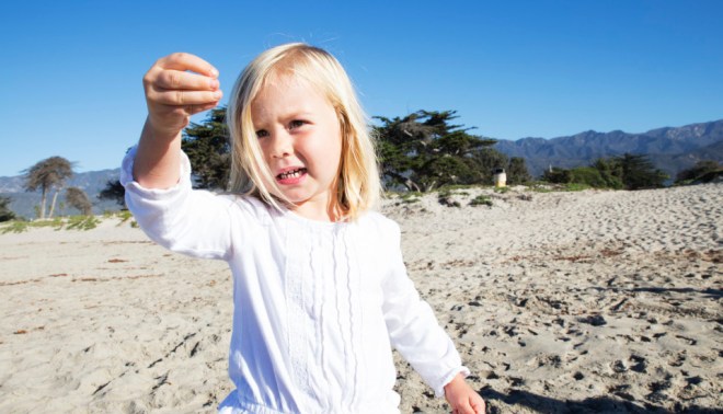 3-year-old Hazel stops to inspect a piece of beach debris. 