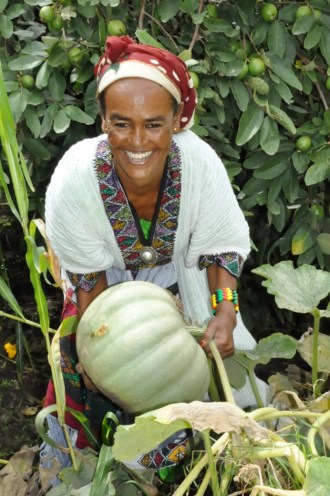 Birtukan Dagnachew holding a squash in her farm in the Woldiya District of the Amhara, Ethiopia