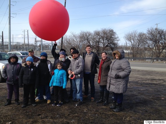 A group of area residents and activists poses with the weather balloon rig they are using to monitor petcoke operations in their neighborhood.