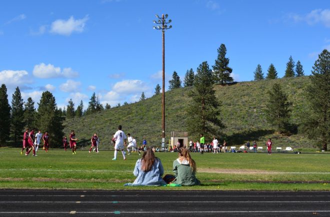 Students at Liberty Bell High School watch a soccer game against the Okanogan High School team.