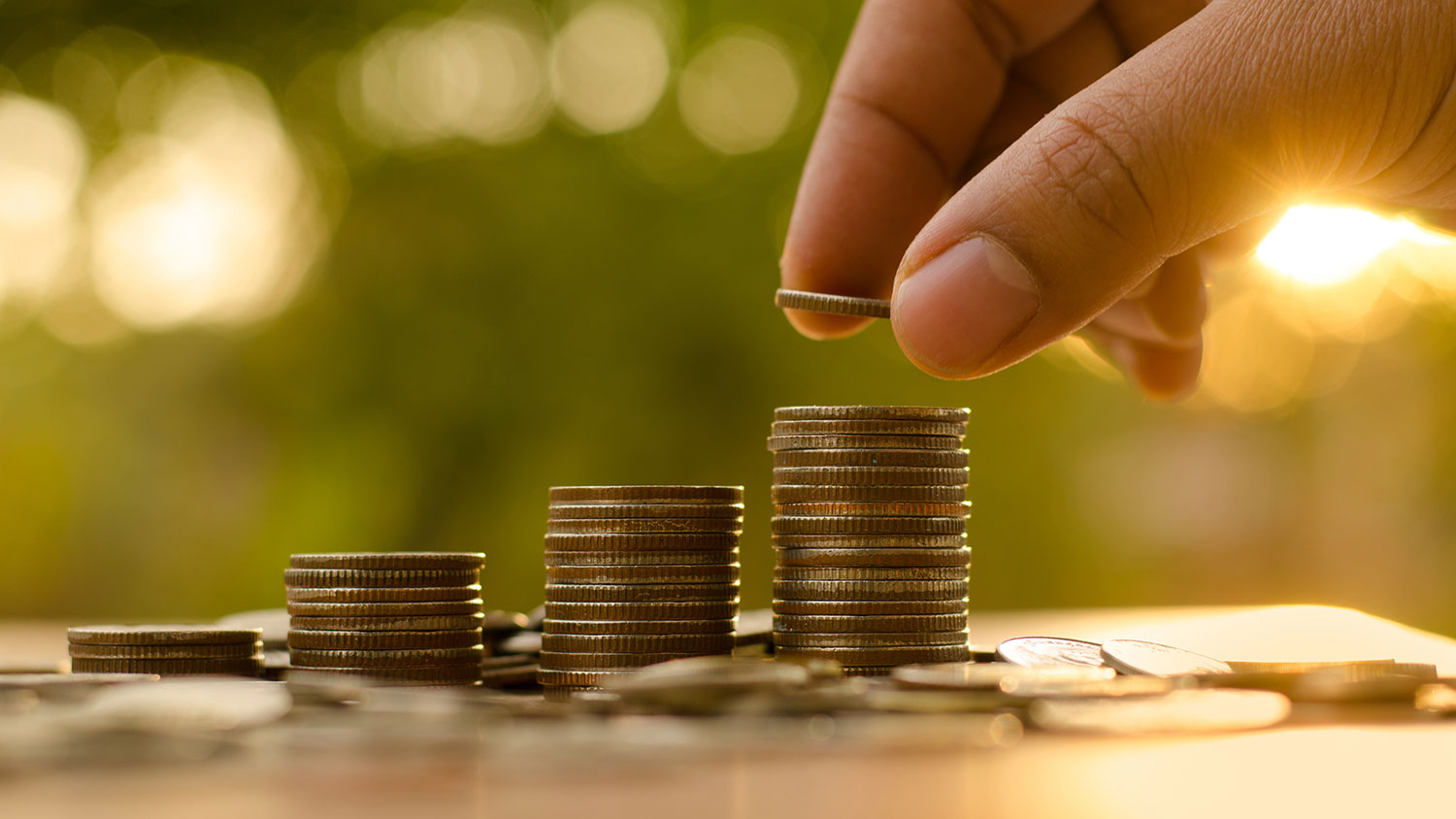 a hand stacking coins