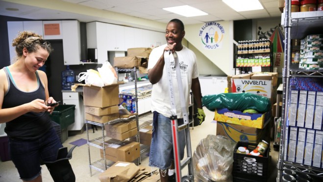 Food for Free driver Adam Collins chats with Food Pantry Coordinator Ariela Knight at the Elizabeth Peabody House, a food pantry in Somerville, Mass.