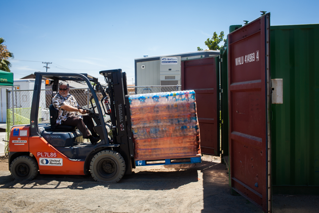 Pastor Roman Hernandez prepares free bottled water for locals to pick up. 