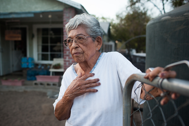 Vicky Yorba, 95, stands beside the water tank in her front yard.