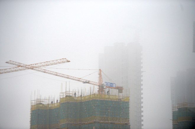 A construction site is seen covered in smog in Jinan, Shandong province, China, November 10, 2015. 