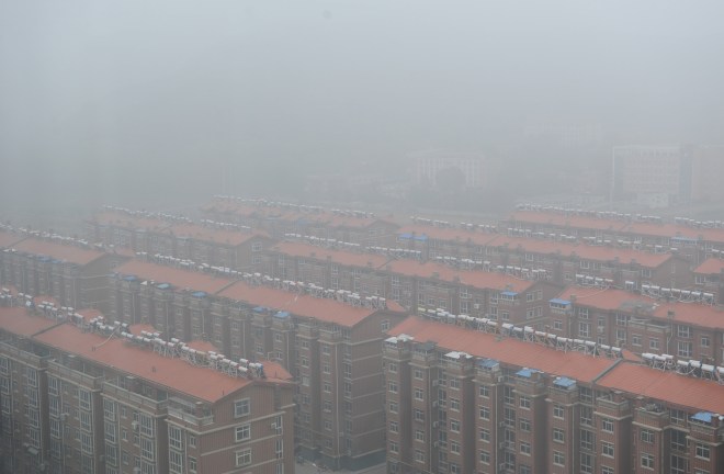 Residential buildings are seen surrounded in smog in Jinan, Shandong province, China, November 10, 2015. 