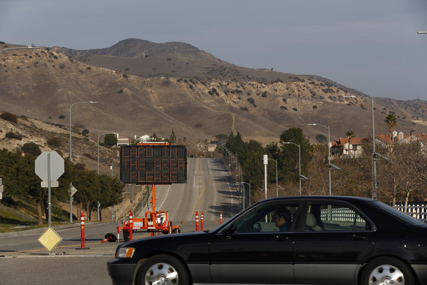 A car drives past an illuminated display on Sesnon Blvd. warning would be burglars that the LAPD is in the area and to encourage residents -- those who have stayed -- to call 911 if they see criminal activity.