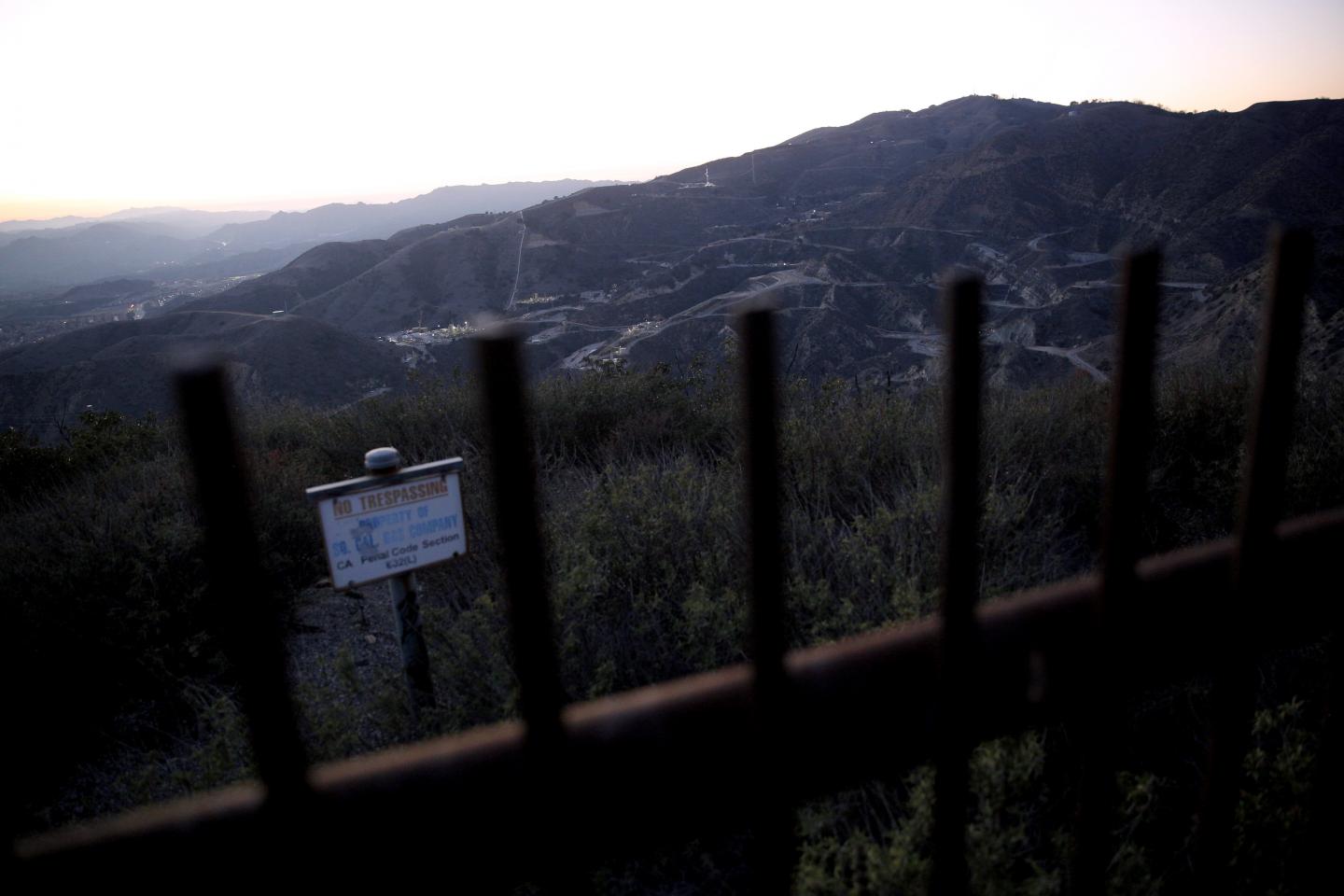 A "No Trespassing" sign and fence mark the boundary of the SoCalGas Aliso Canyon Storage Facility, looking toward where a leaking gas well and a relief well are being drilled. Public trails crisscross the hills near the well where the smell of gas was strong on Dec. 30, 2015.