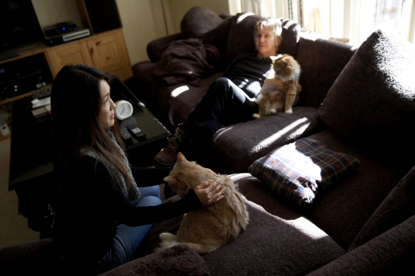 Co-founders of Save Porter Ranch Kyoko Hibino, left, and Matt Pakucko sit on their couch with their cats. The pair are trying to raise awareness of the nearly three-month-old gas leak and urge lawmakers to act.