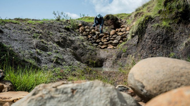 CIAT researcher Tesfaye Tesfamichael demonstrating the installation of check dams to prevent soil loss on the slopes. 