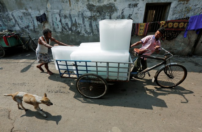 Men transport ice on a tricycle to a local market in Kolkata, India May 24, 2016. REUTERS/Rupak De Chowdhuri - RTSFN2B