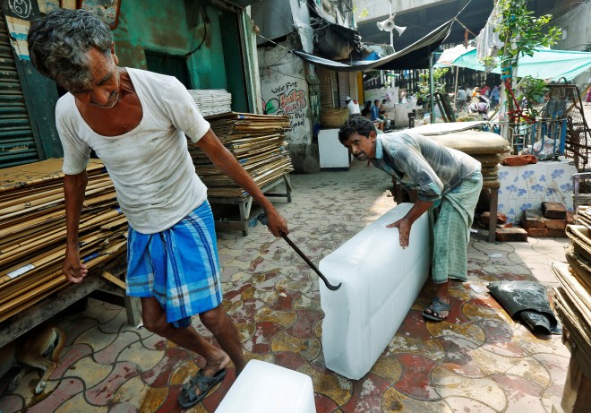 Men unload blocks of ice from a tricycle at a local market in Kolkata, India May 24, 2016. REUTERS/Rupak De Chowdhuri - RTSFN4Y