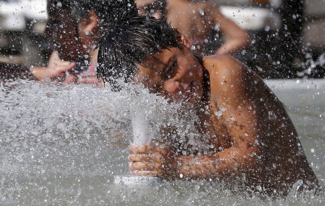 A boy cools off with water inside a monument, during a heatwave hitting the country, in Vina del Mar, Chile, January 17, 2016. REUTERS/Rodrigo Garrido - RTX22SK6