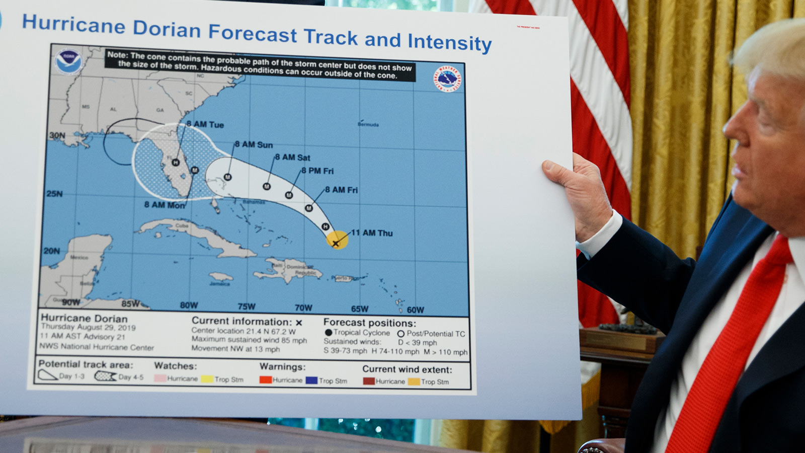 President Donald Trump holds a chart as he talks with reporters