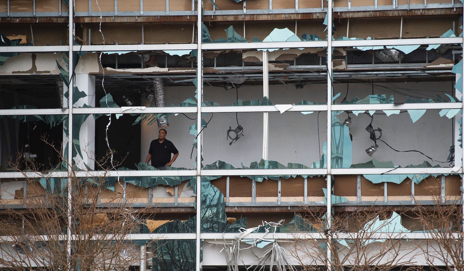 A man looks at damage inside the Capitol One Bank Tower, with its windows blown out in the downtown area after Hurricane Laura passed through