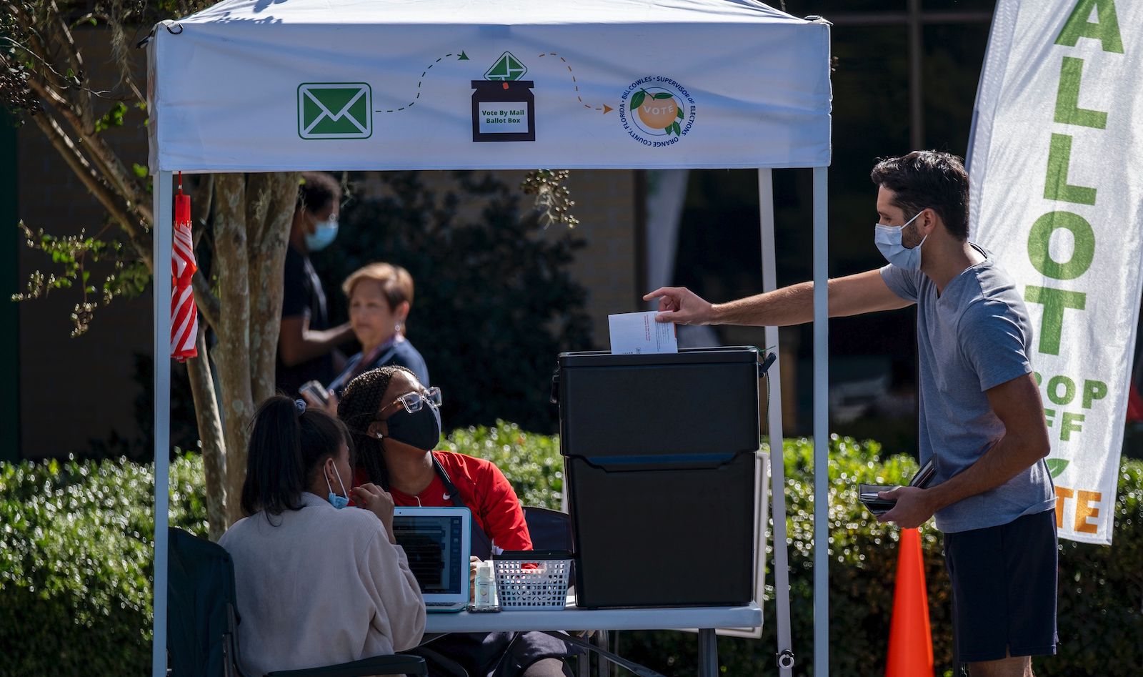 A man dropping off his ballot at an Orange County, Florida voting booth