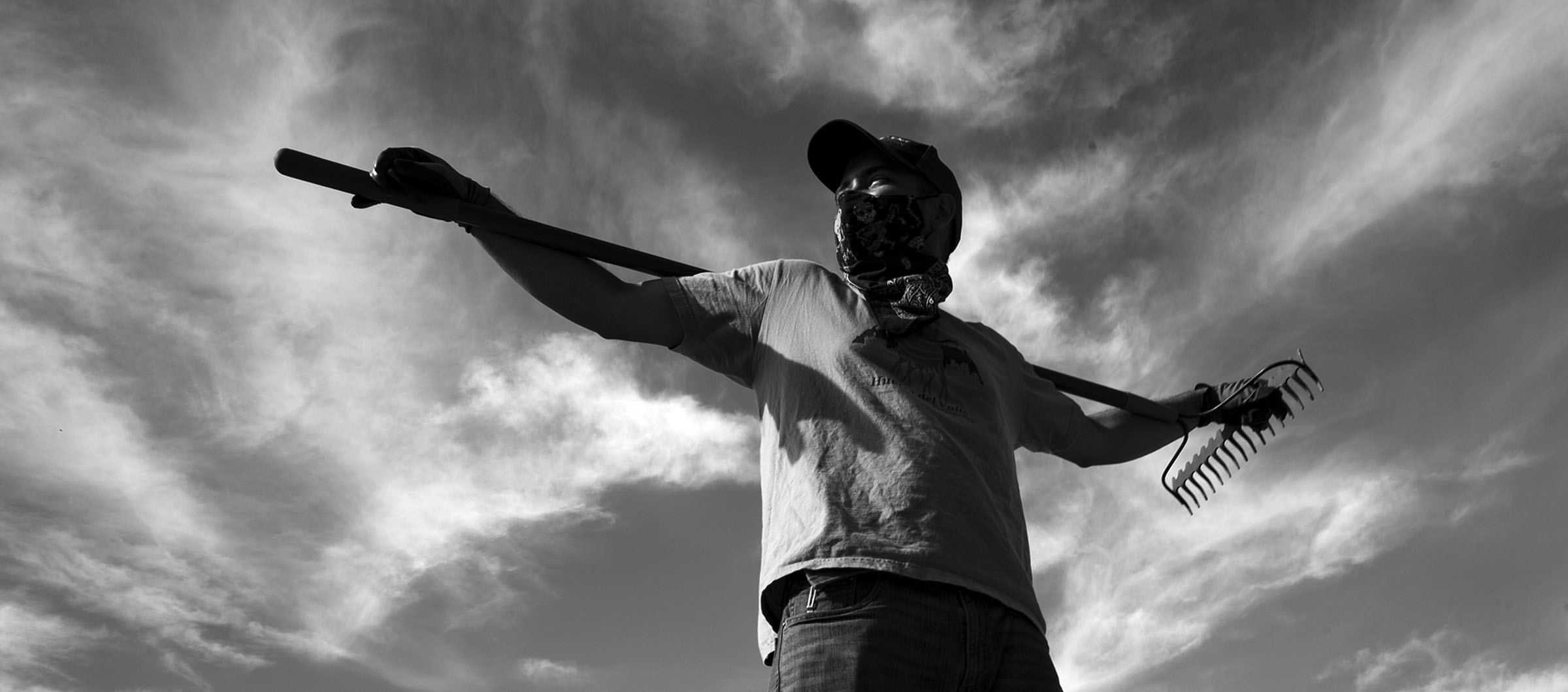 Community garden volunteer Samuel Armando Castro Marron, 28, of San Bernardino, helps create a new plot for a future garden. As he uses the rake to stretch his arms and back he looks the part of a human scarecrow.