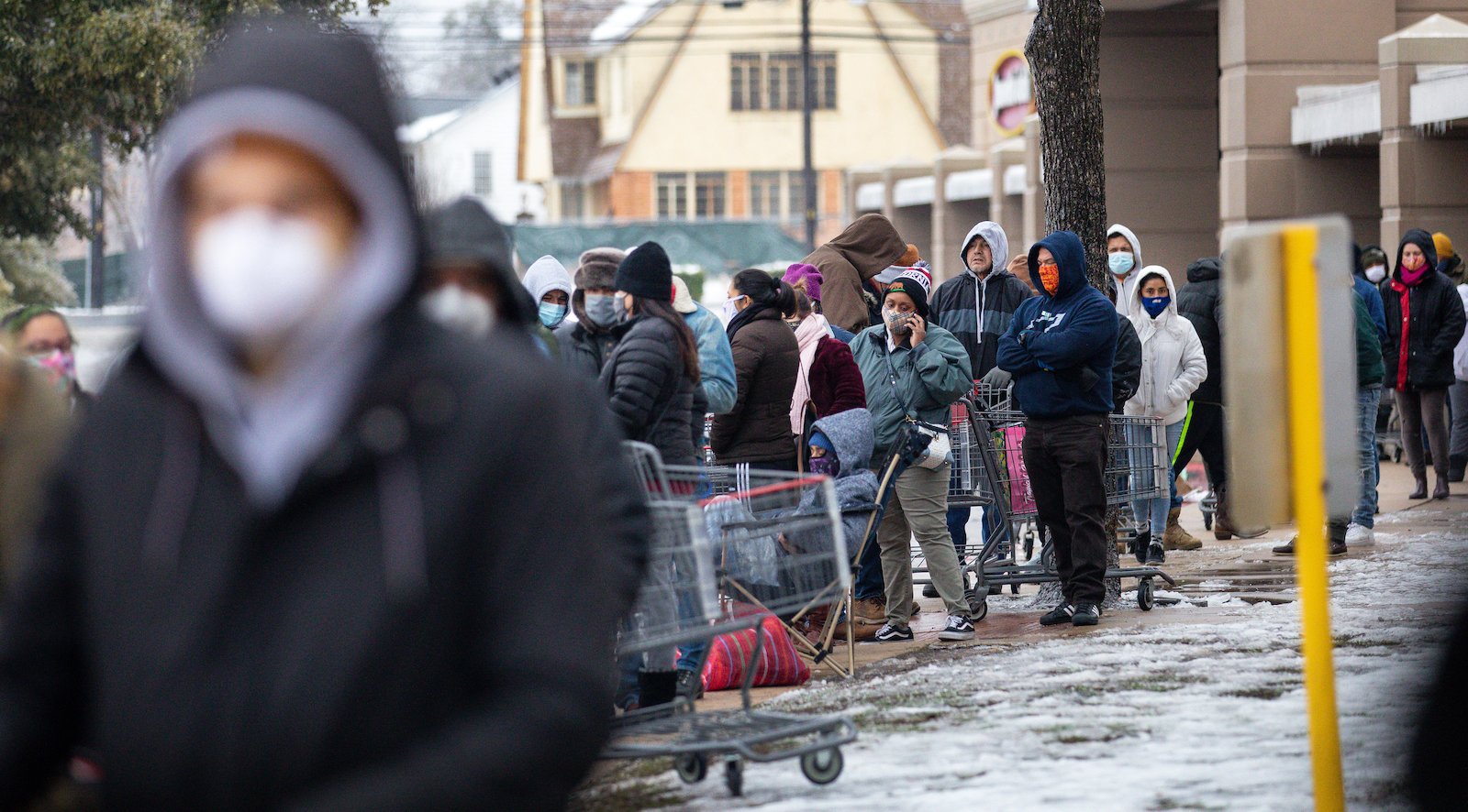 AUSTIN, TX - FEBRUARY 17, 2021: People wait in long lines at an H-E-B grocery store in Austin, Texas on February 17, 2021. Millions of Texans are still without water and electric as winter storms continue.