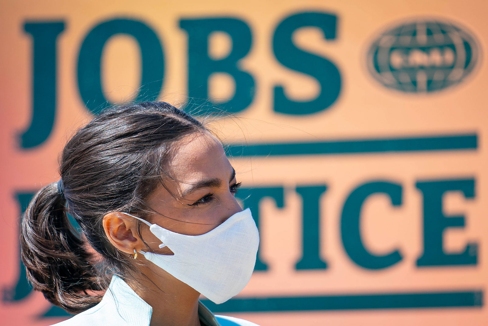 Alexandria Ocasio-Cortez listens during a news conference held to re-introduce the Green New Deal