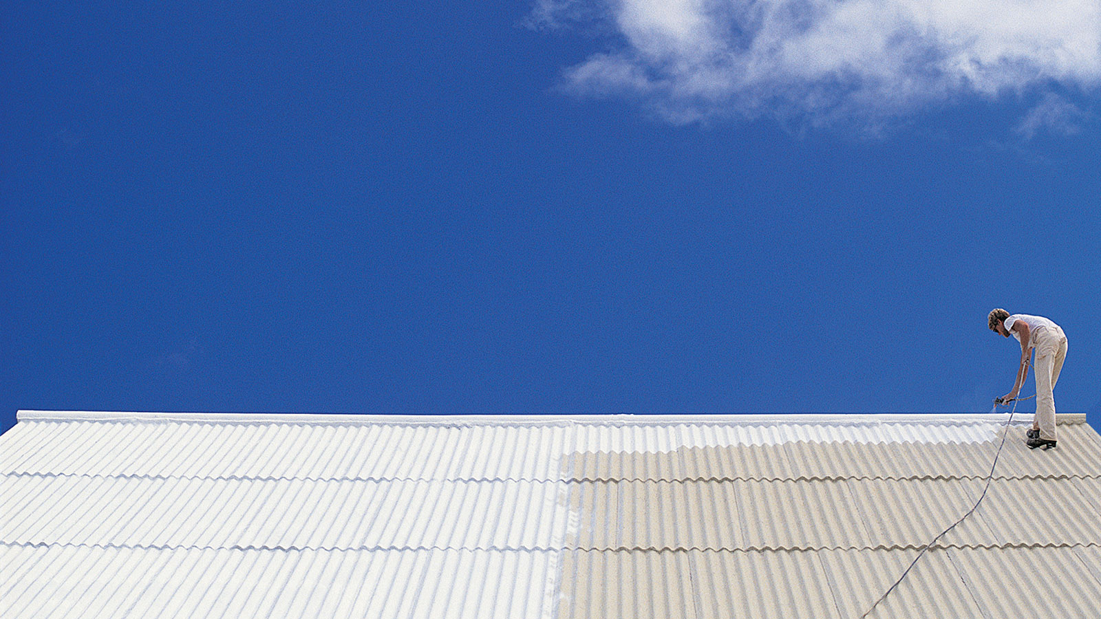 Man painting a roof white