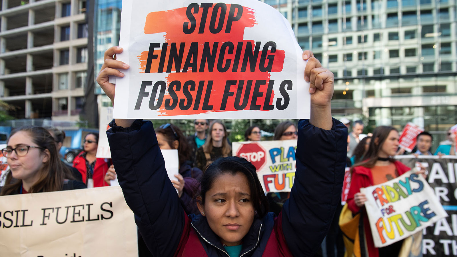 A young woman at a protest holding a sign that reads 