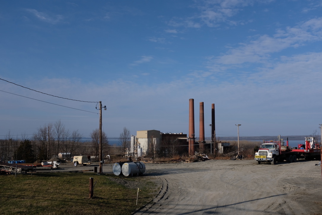 a photo of a power plant with red stacks against a blue sky