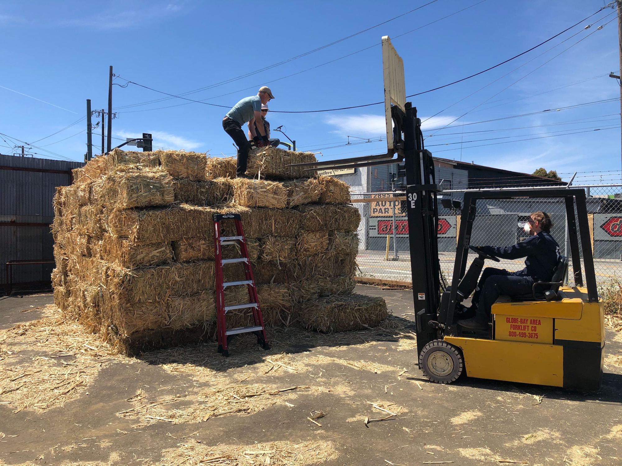 Charm Industrial staffers arrange bales of farm waste.