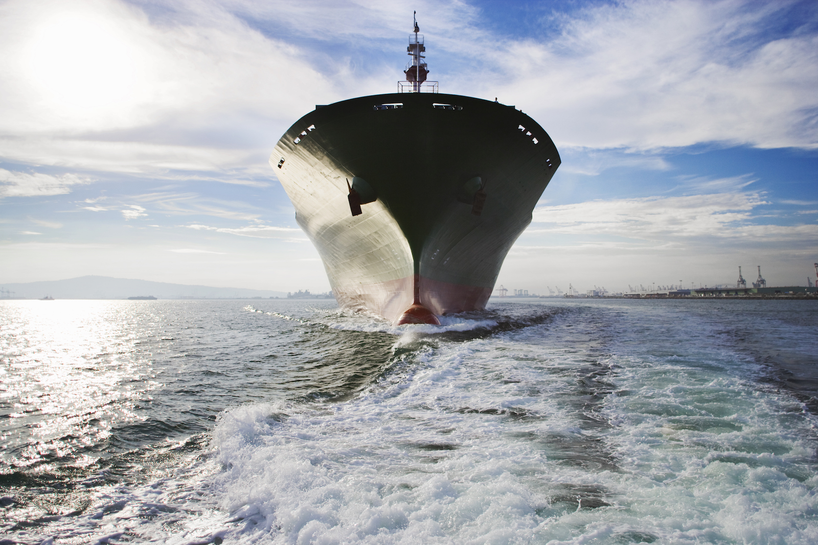 a photo taken from the back of a large cargo ship with wake in the foreground