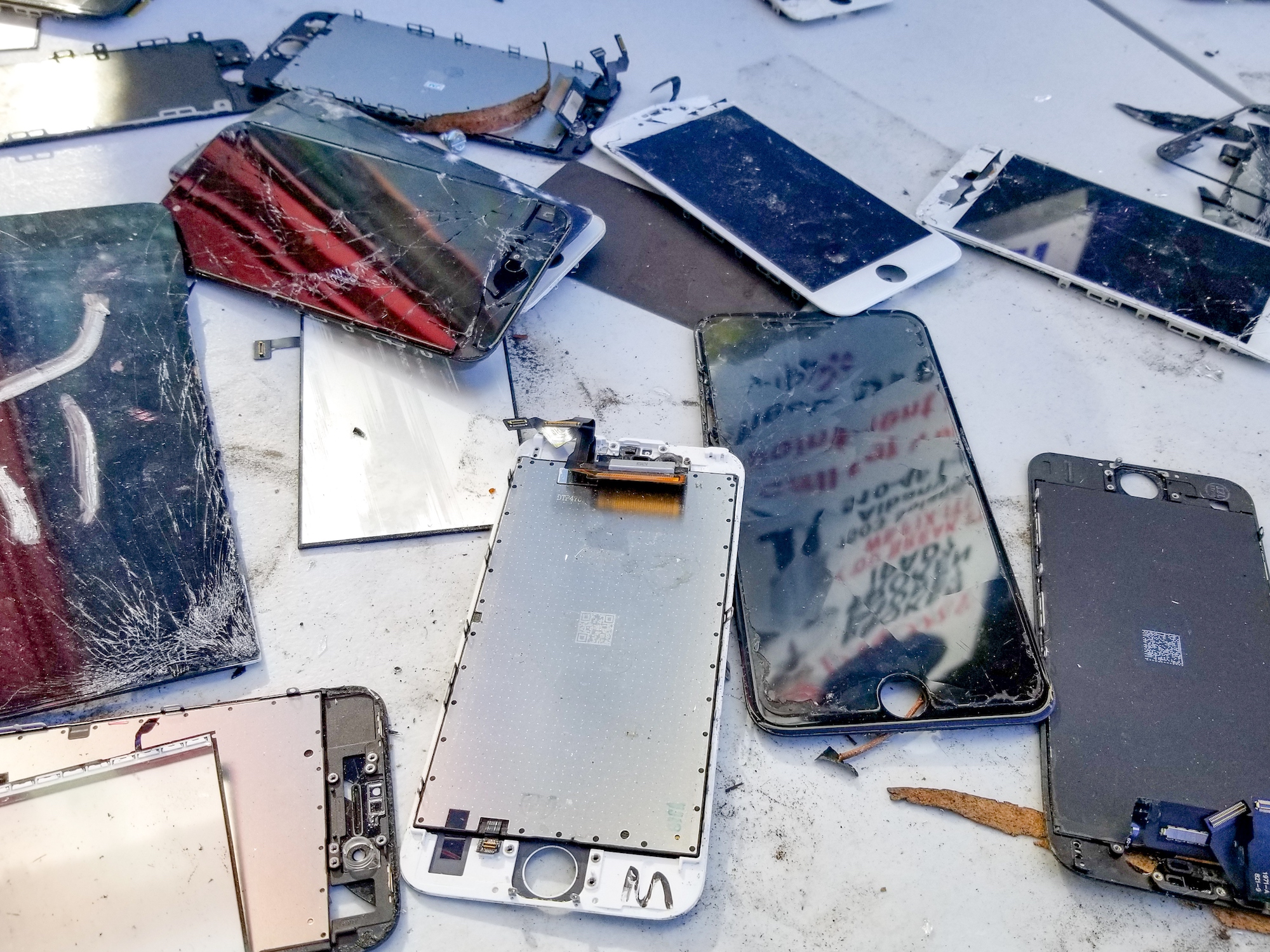 a close-up photo of broken cell phones of various types