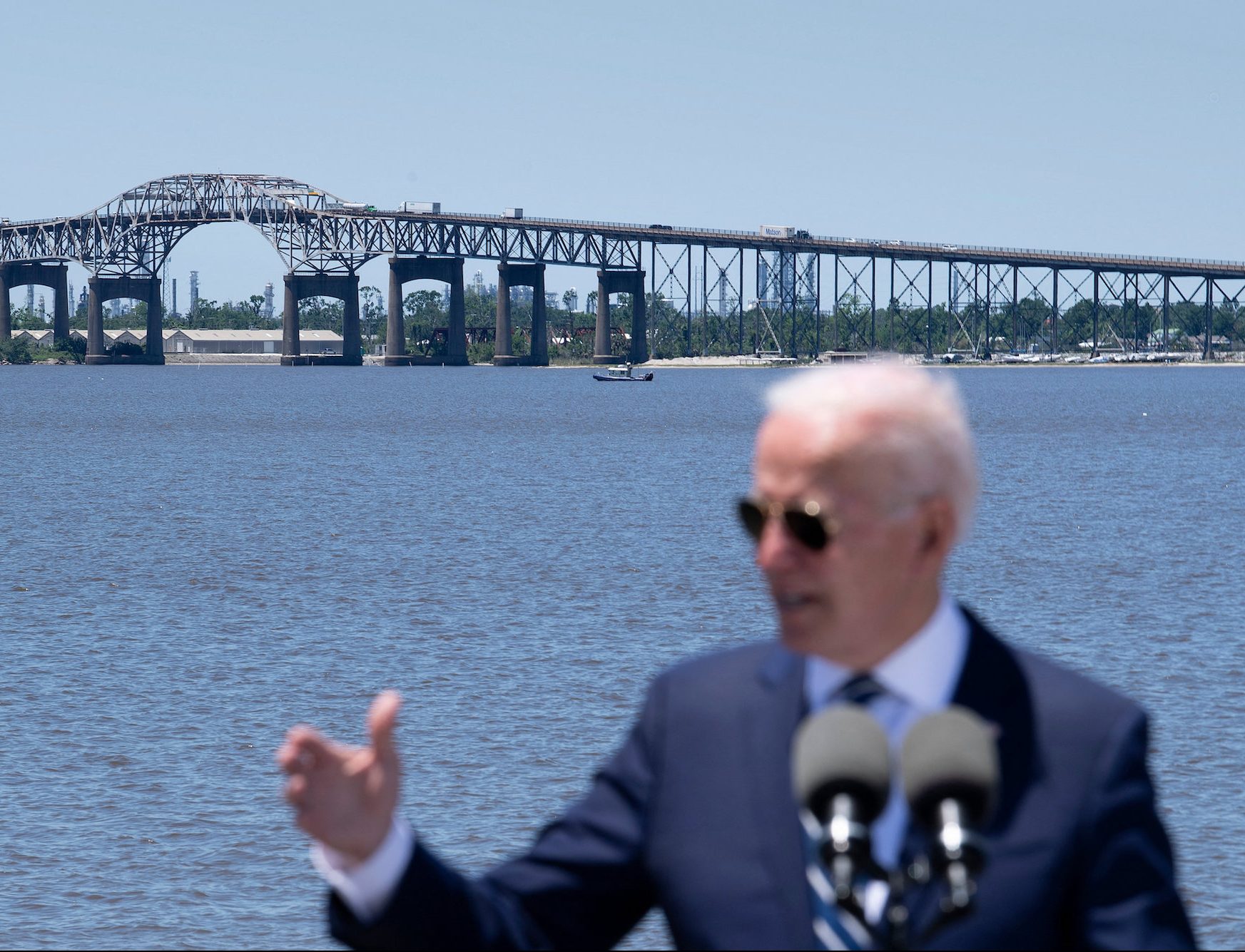 biden speaking in front of bridge and water