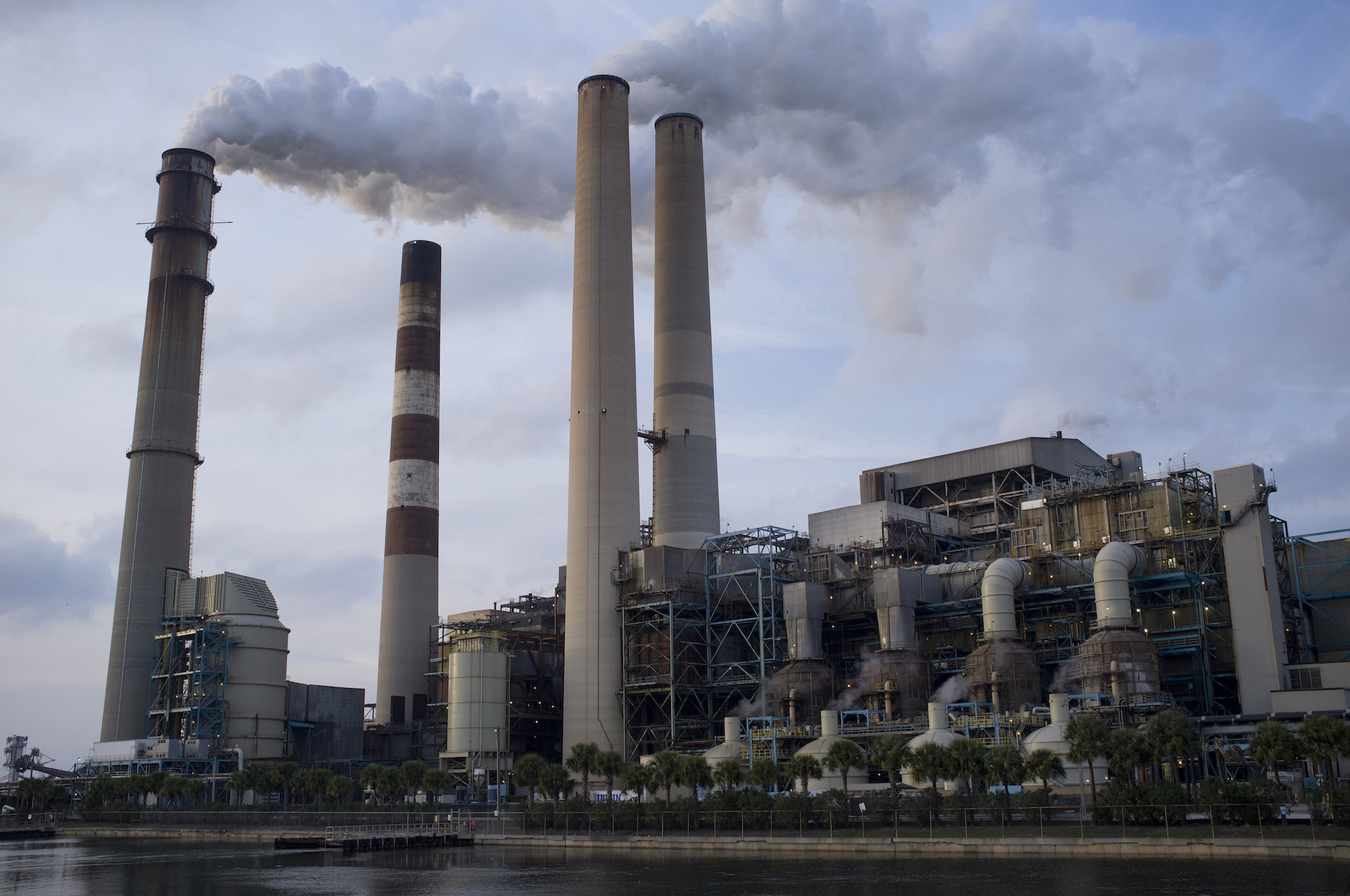 a large power plant with stacks spewing smoke