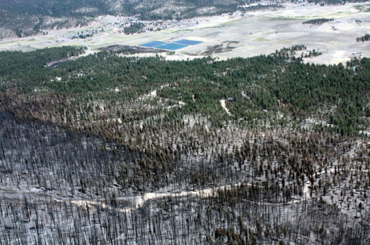 The fire burned down the hill leaving a black area, as it encountered the treatment unit (brown area) and approached residences (green area). The treatment edge is obvious as is the change in fire behavior.