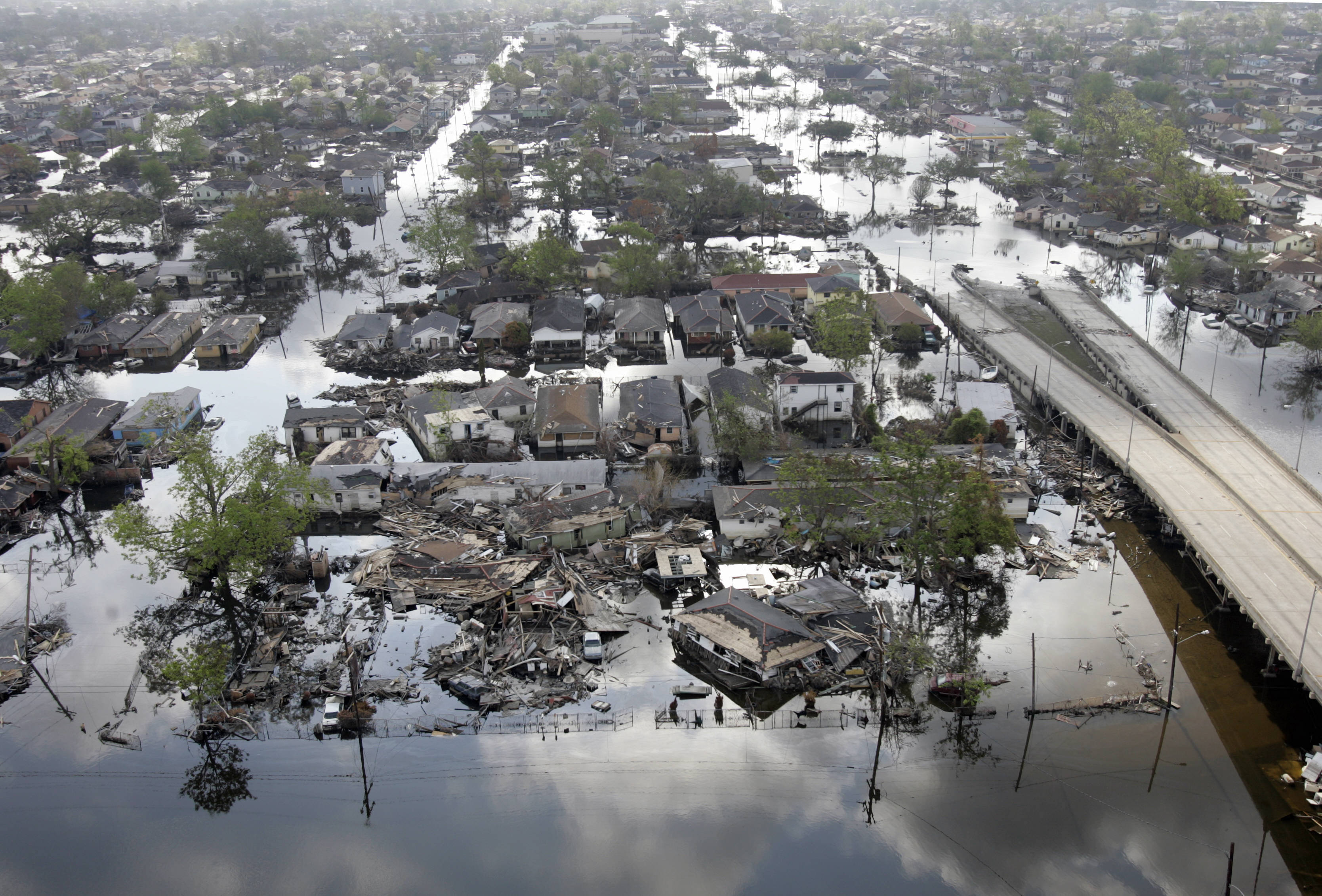 An aerial shot of houses destroyed as well as a highway and roads flooded.