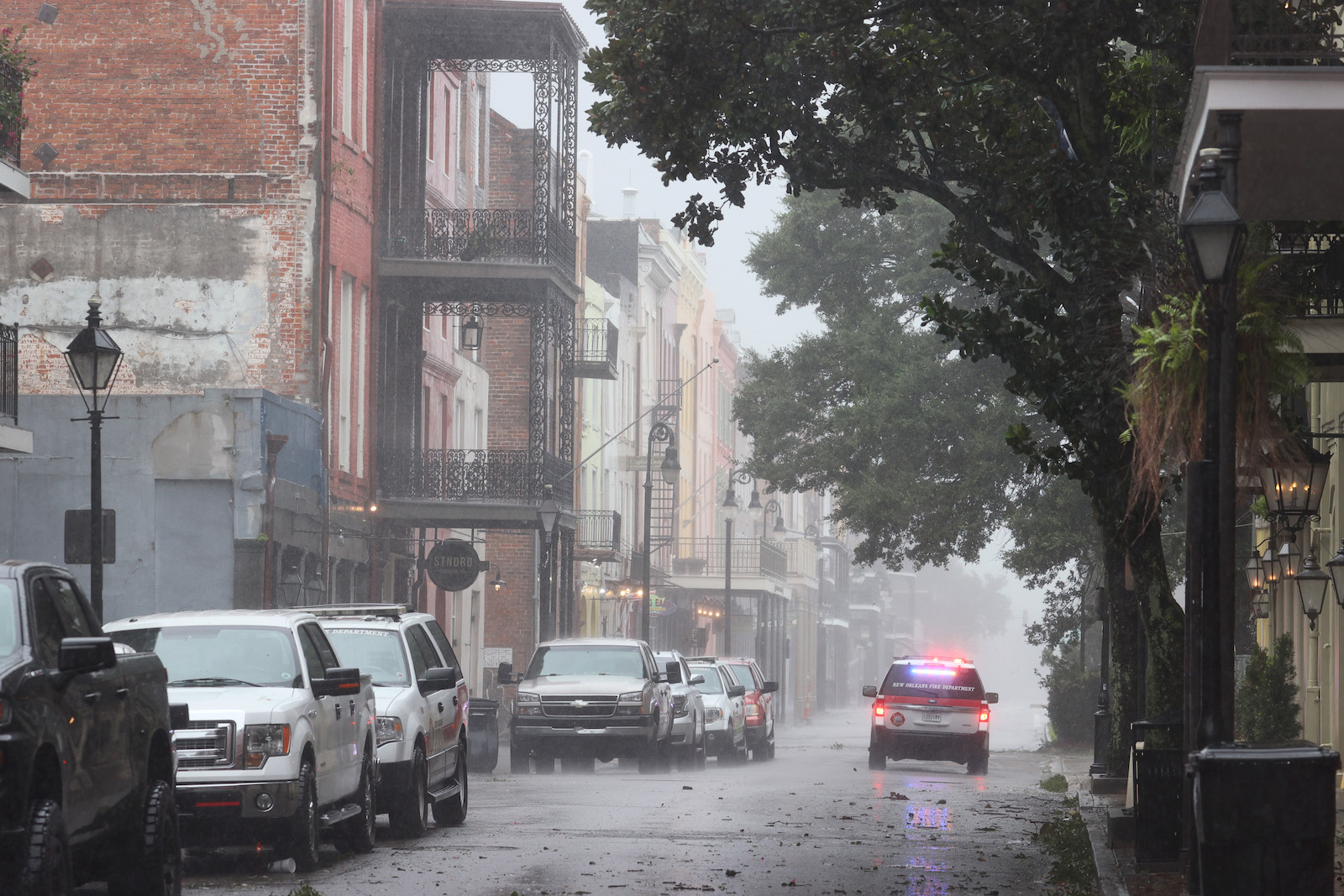 An emergency response vehicle cruises through a street battered by Hurricane Ida