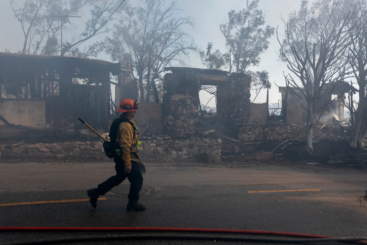 A firefighter walks past homes in Los Angeles burnt in the Woolsey Fire in 2018.