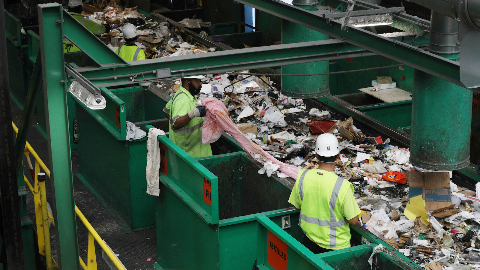 Workers sort plastic at a recycling center.