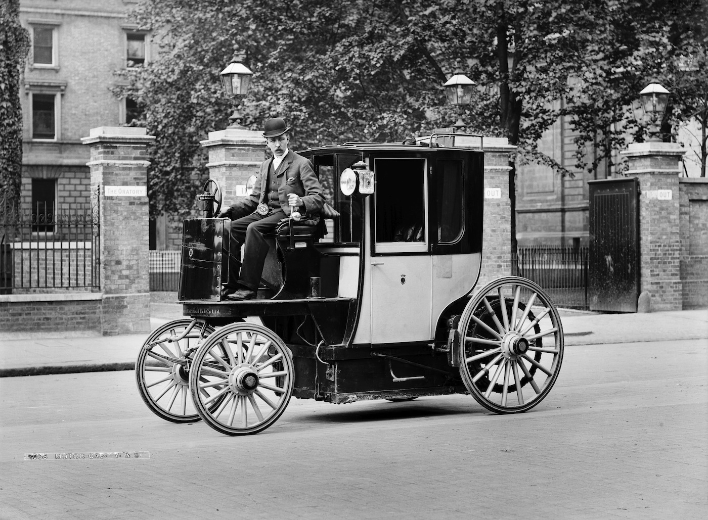 Black and white photo of an old cab on the street.