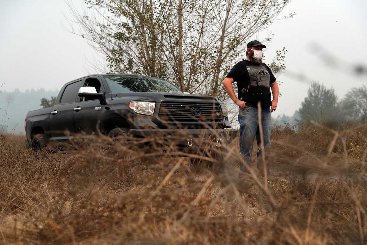 Smoke and dust blow off the burned remnants of Jesse Merrick's family's home after the 2017 Thomas Fire